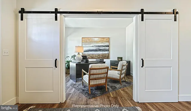 a view of a hallway to a livingroom with furniture and wooden floor