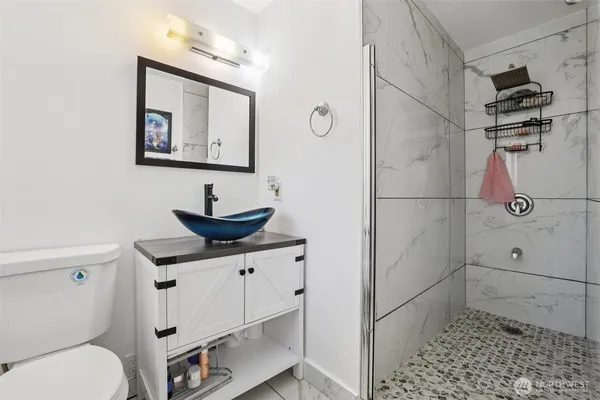 a bathroom with a sink a toilet and shower