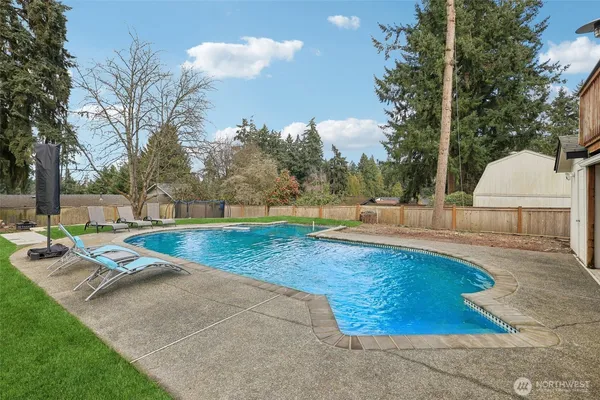 a view of a backyard with swimming pool