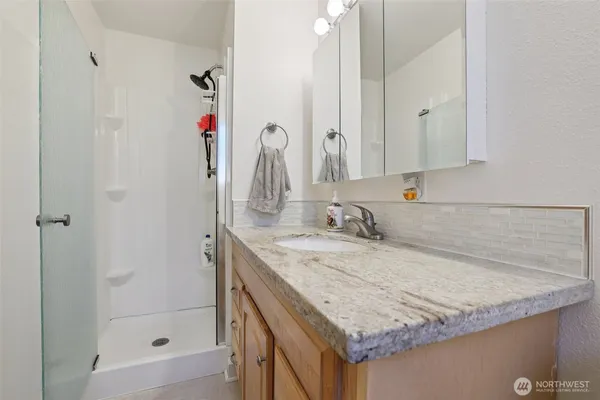 a bathroom with a granite countertop sink and a mirror