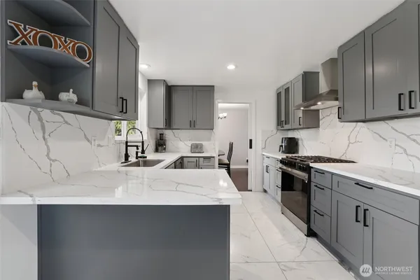 a large kitchen with stainless steel appliances a sink a stove and a refrigerator