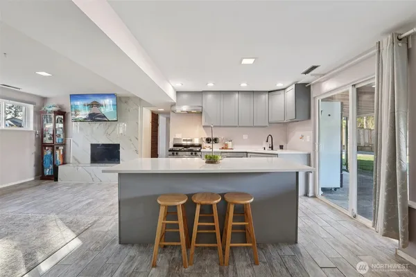 a kitchen with stainless steel appliances granite countertop a table chairs sink refrigerator and cabinets