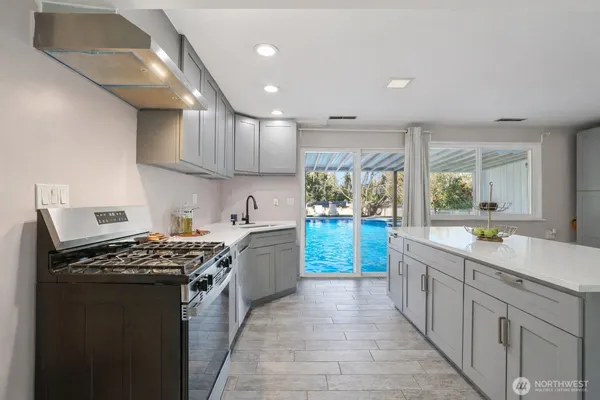 a kitchen with stainless steel appliances a sink stove and cabinets