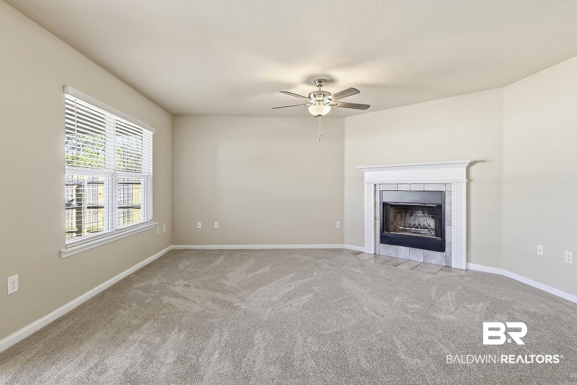 983 Summerton Drive Foley, AL 36535 - Photo 8 of 25 Unfurnished living room with light carpet, a tile fireplace, and a ceiling fan