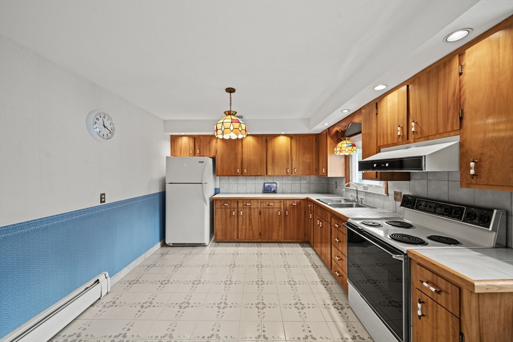 7 Cedarcrest Road Salem, MA 01970 - Photo 9 of 41 a kitchen with stainless steel appliances granite countertop a stove a sink and a refrigerator