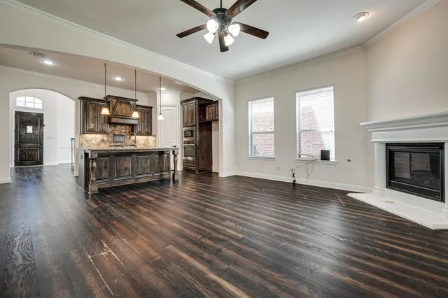 a living room with stainless steel appliances granite countertop furniture wooden floor and a fireplace