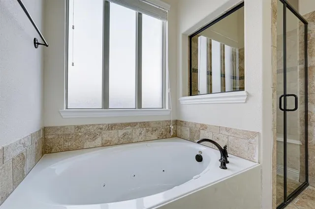 a bathroom with bathtub and window