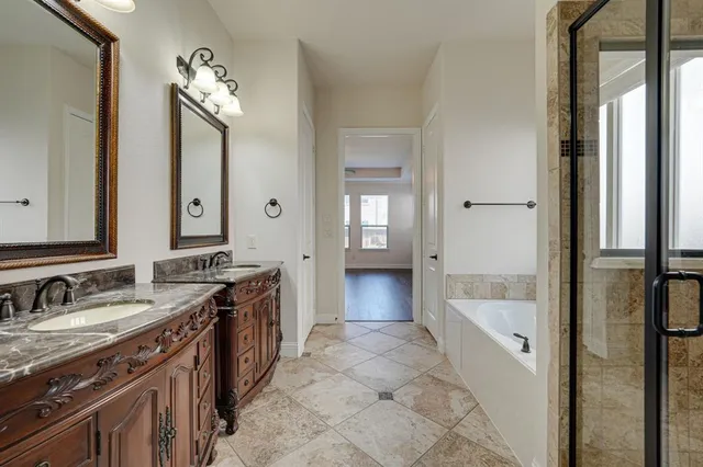 a spacious bathroom with a tub sink and mirror