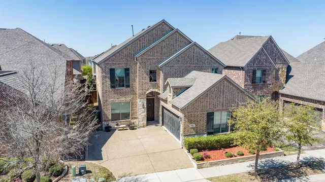 a front view of house with yard and trees in the background