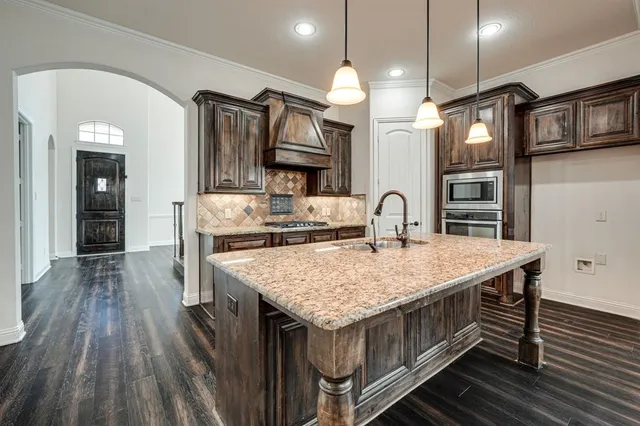 a kitchen with kitchen island white cabinets and stainless steel appliances