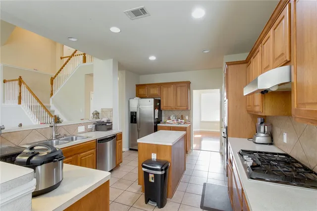 a kitchen with stainless steel appliances a sink stove and refrigerator