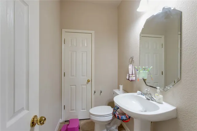 a bathroom with a sink toilet and a mirror