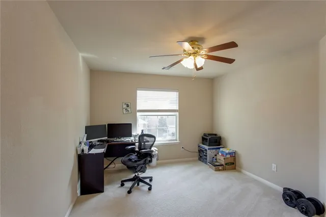 a view of a workspace with furniture and a window