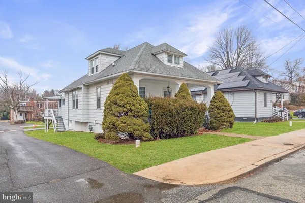 a view of a livingroom with wooden floor and kitchen space