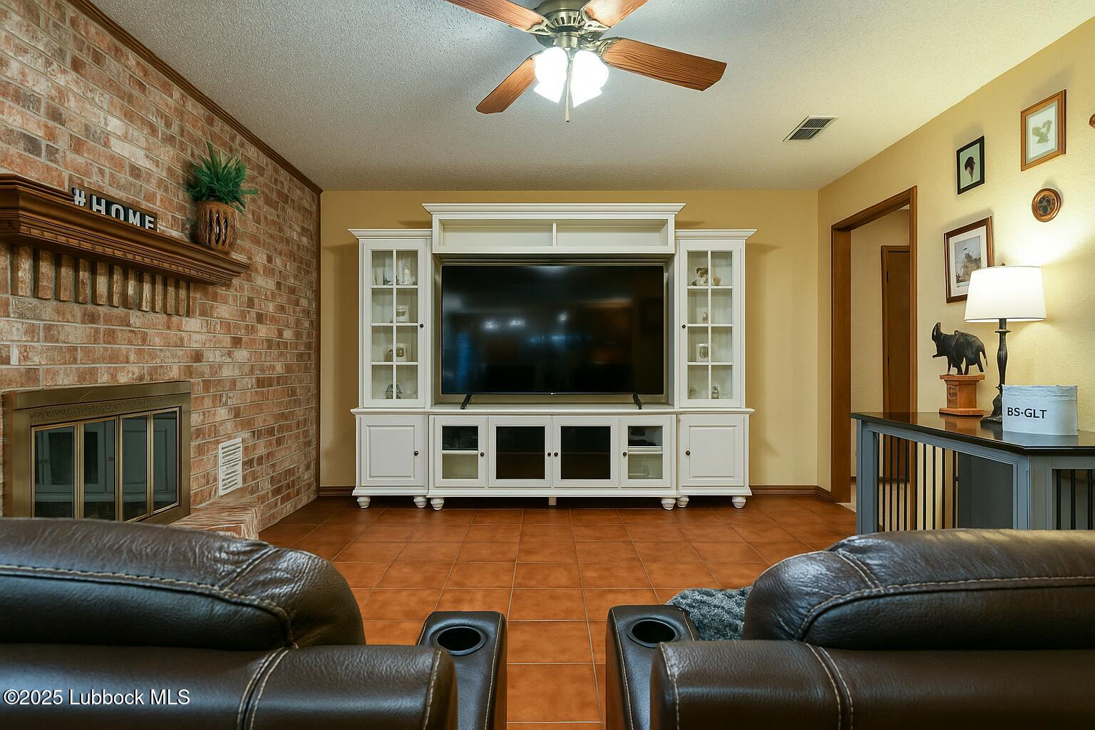 208 South Holliday Plainview, TX 79072 - Photo 5 of 32 a living room with furniture a flat screen tv and a fireplace