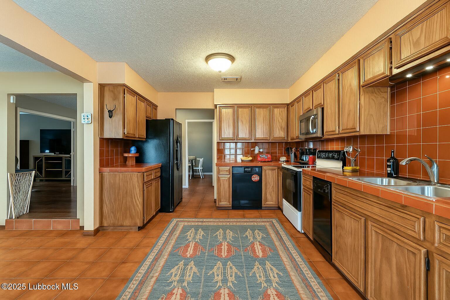 208 South Holliday Plainview, TX 79072 - Photo 10 of 32 a kitchen with stainless steel appliances a refrigerator and a sink