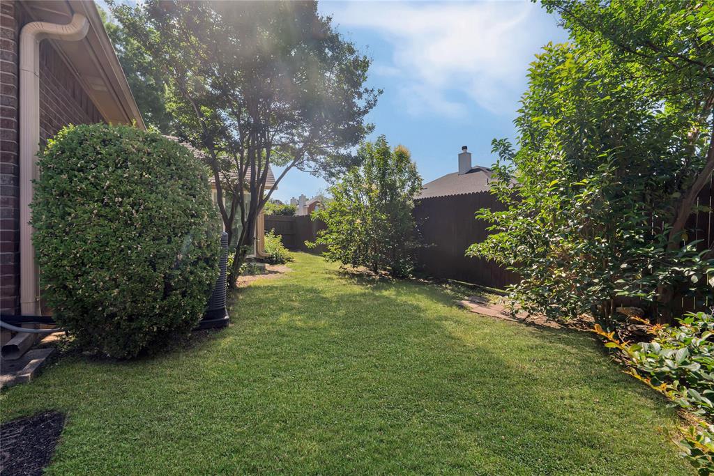 2909 Normandy Court Euless, TX 76039 - Photo 31 of 36 a view of a backyard with plants and a large tree
