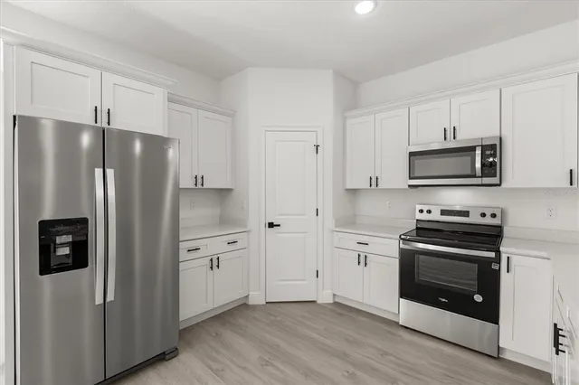 a kitchen with stainless steel appliances a refrigerator stove and microwave