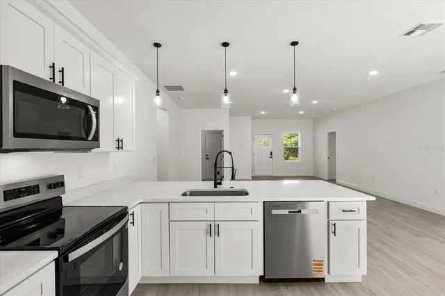 a kitchen with a sink stainless steel appliances and cabinets