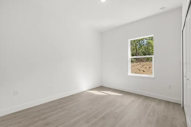 an empty room with wooden floor and window