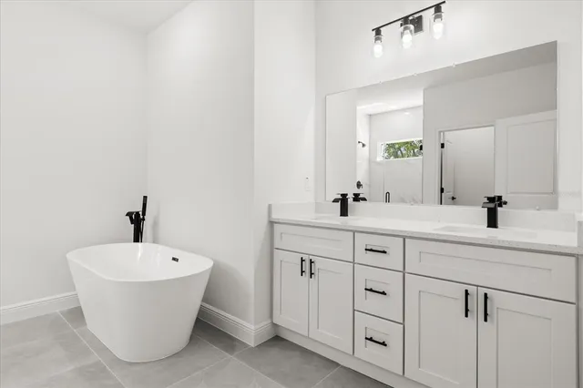 a bathroom with a white tub a sink and mirror