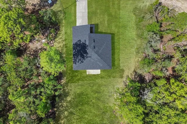 an aerial view of a house with a yard