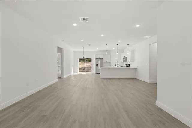 a view of an empty room with a kitchen