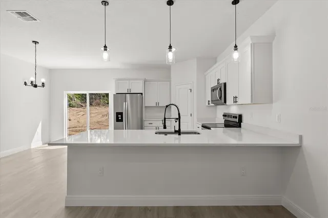 a large kitchen with granite countertop a sink a counter top space a stove and cabinets