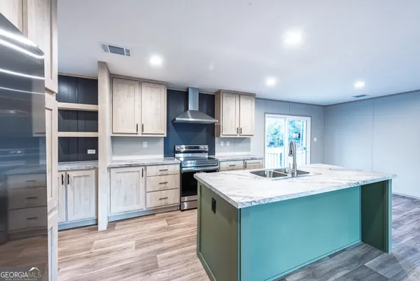 a kitchen with kitchen island granite countertop a sink cabinets and stainless steel appliances