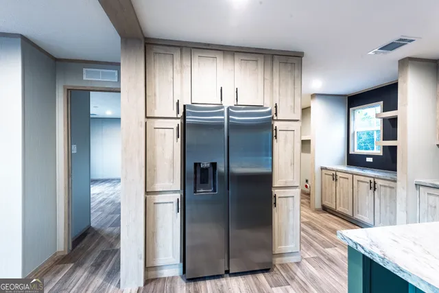 a kitchen with stainless steel appliances granite countertop a refrigerator and a sink