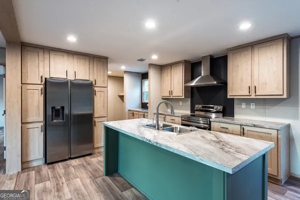 a kitchen with kitchen island granite countertop a sink stove and refrigerator