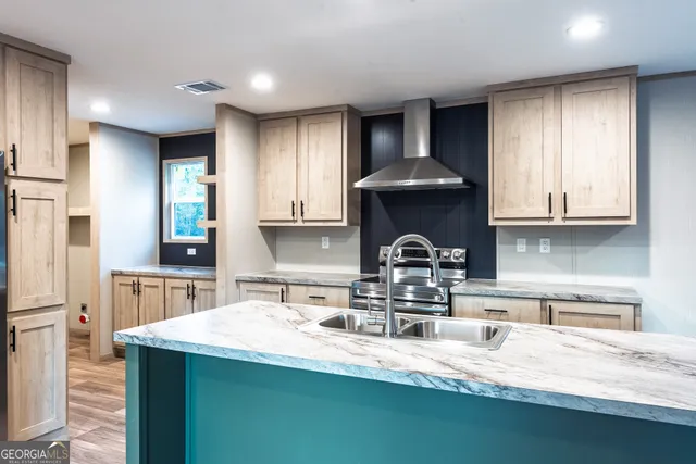 a kitchen with stainless steel appliances granite countertop a sink a stove and a refrigerator