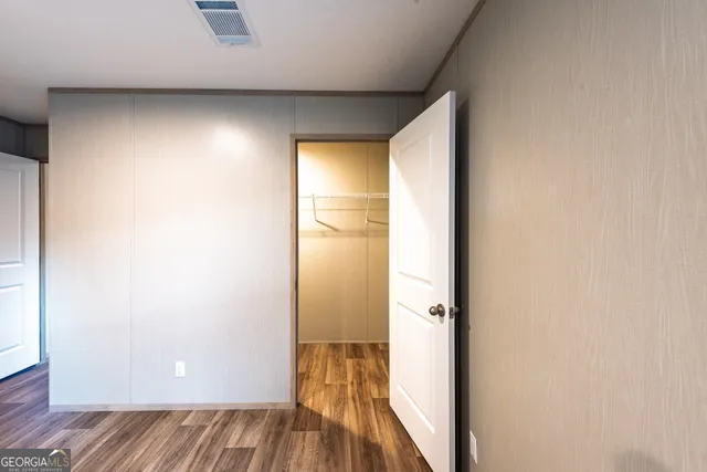 a view of walk in closet with wooden floor