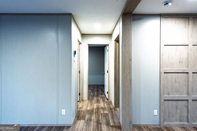 a view of a hallway with wooden floor and a cabinet