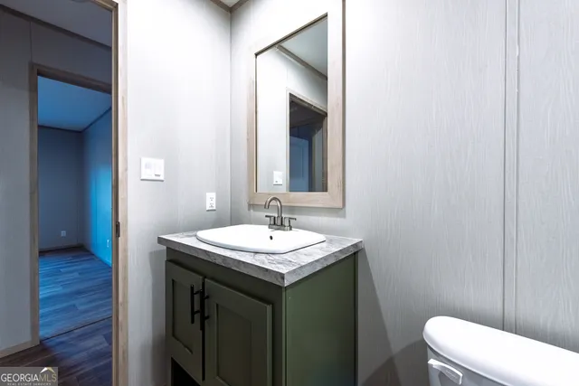 a bathroom with a toilet sink and mirror