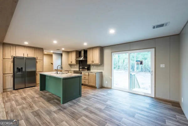a large kitchen with stainless steel appliances granite countertop a large counter top and wooden floors