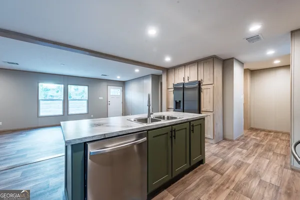 a kitchen with kitchen island granite countertop a sink and wooden cabinets