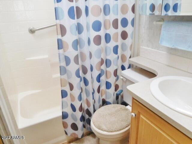 17200 West Bell Road, Unit LOT 760 Surprise, AZ 85374 - Photo 3 of 16 a white toilet sitting next to a white sink and a shower curtain