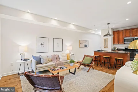a living room with furniture and a dining table with wooden floor
