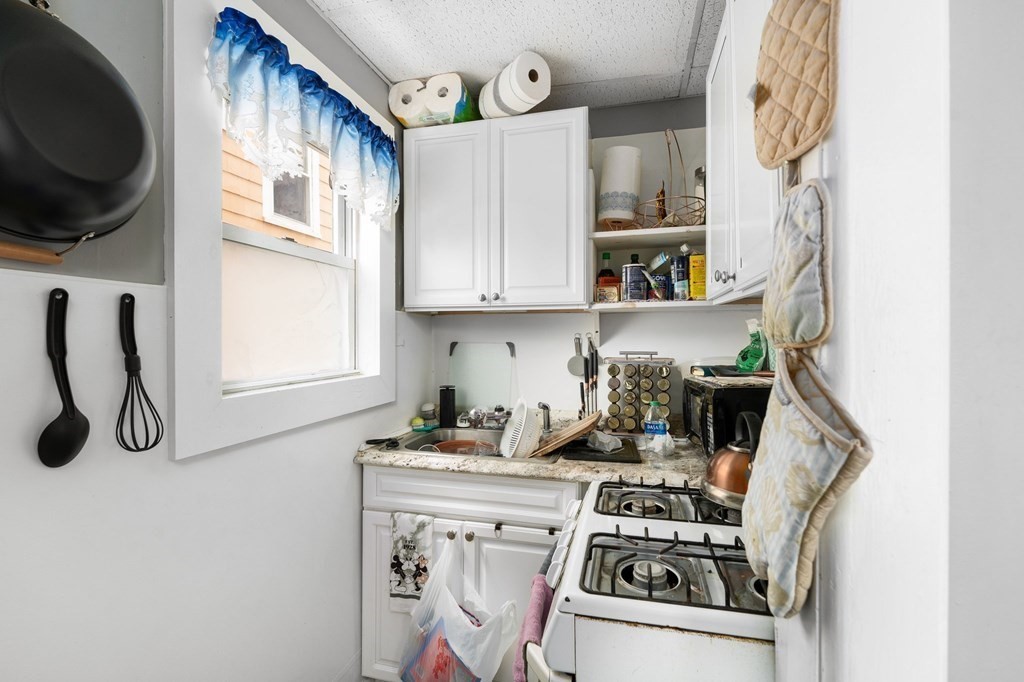 152 Fountain Street Fall River, MA 02721 - Photo 10 of 27 a kitchen with a stove a sink and a microwave