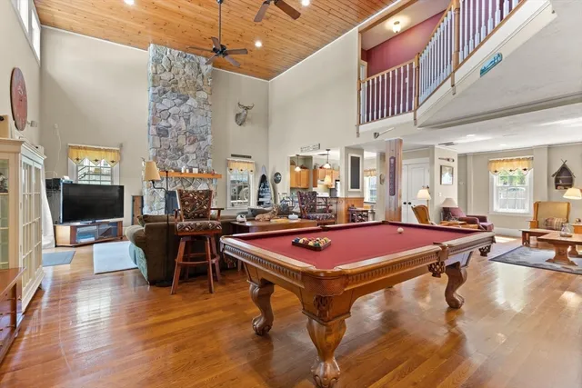 a room with furniture pool table flat screen tv and windows