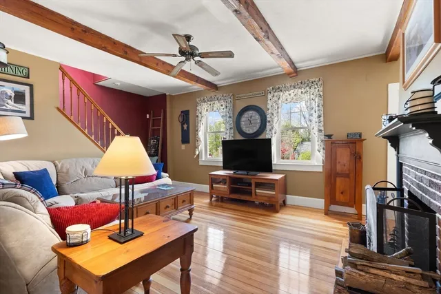a living room with furniture a clock and a flat screen tv