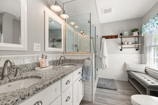 a bathroom with a granite countertop sink toilet and shower