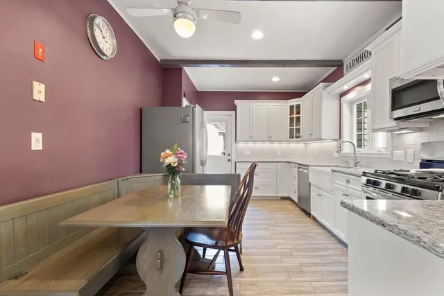 a kitchen with stainless steel appliances granite countertop a stove a refrigerator a kitchen island with a dining table and chairs