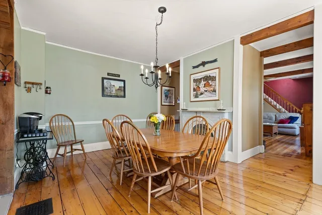 a dining room with furniture a chandelier and wooden floor