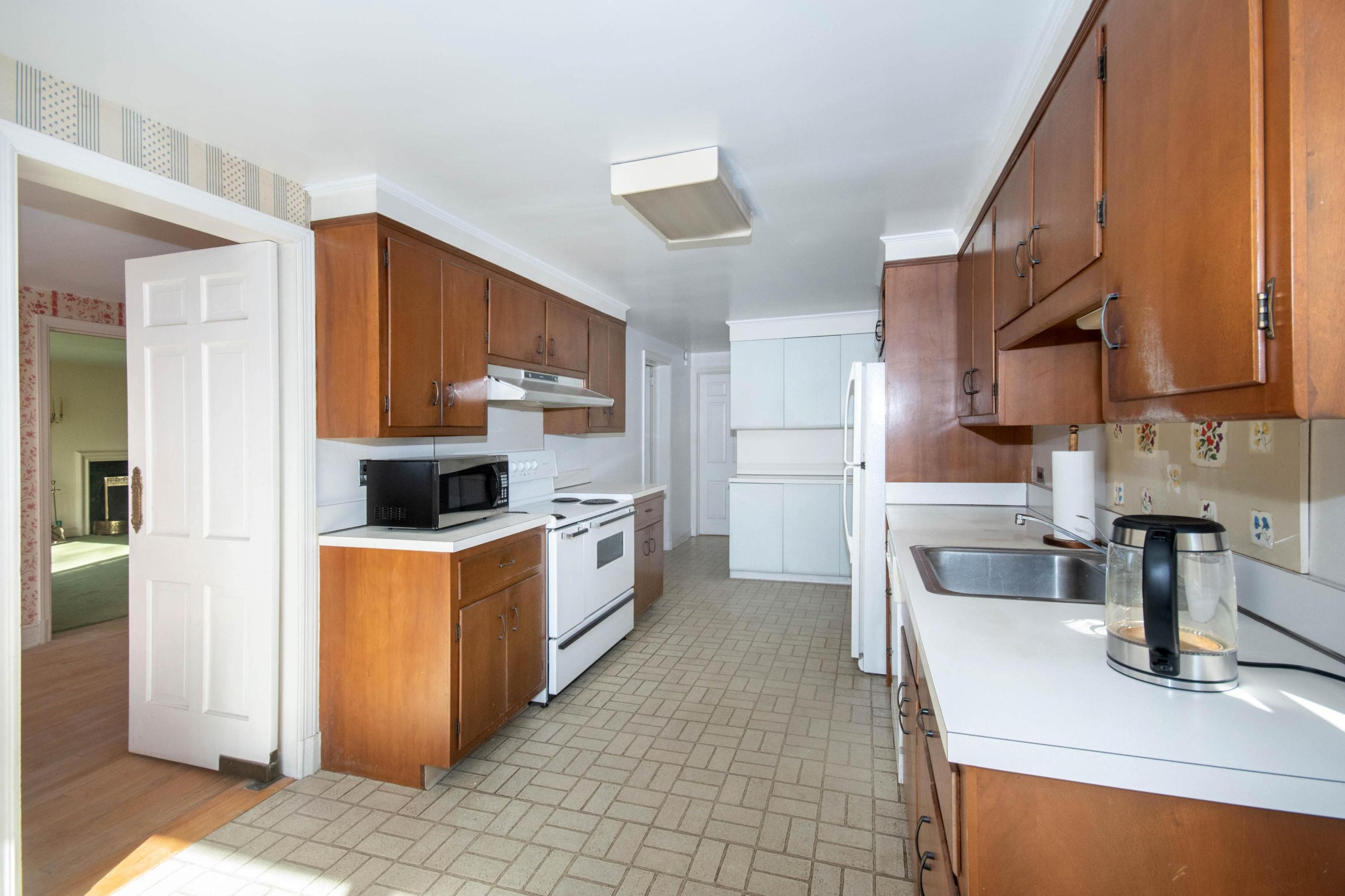 792 Smith Ridge Road New Canaan, CT 06840 - Photo 11 of 18 a kitchen with stainless steel appliances a sink a stove a refrigerator cabinets and a dining table
