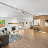 a living room with furniture a fireplace and a floor to ceiling window