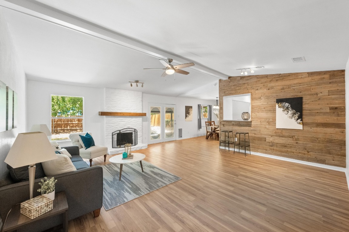 a living room with furniture a fireplace and a floor to ceiling window