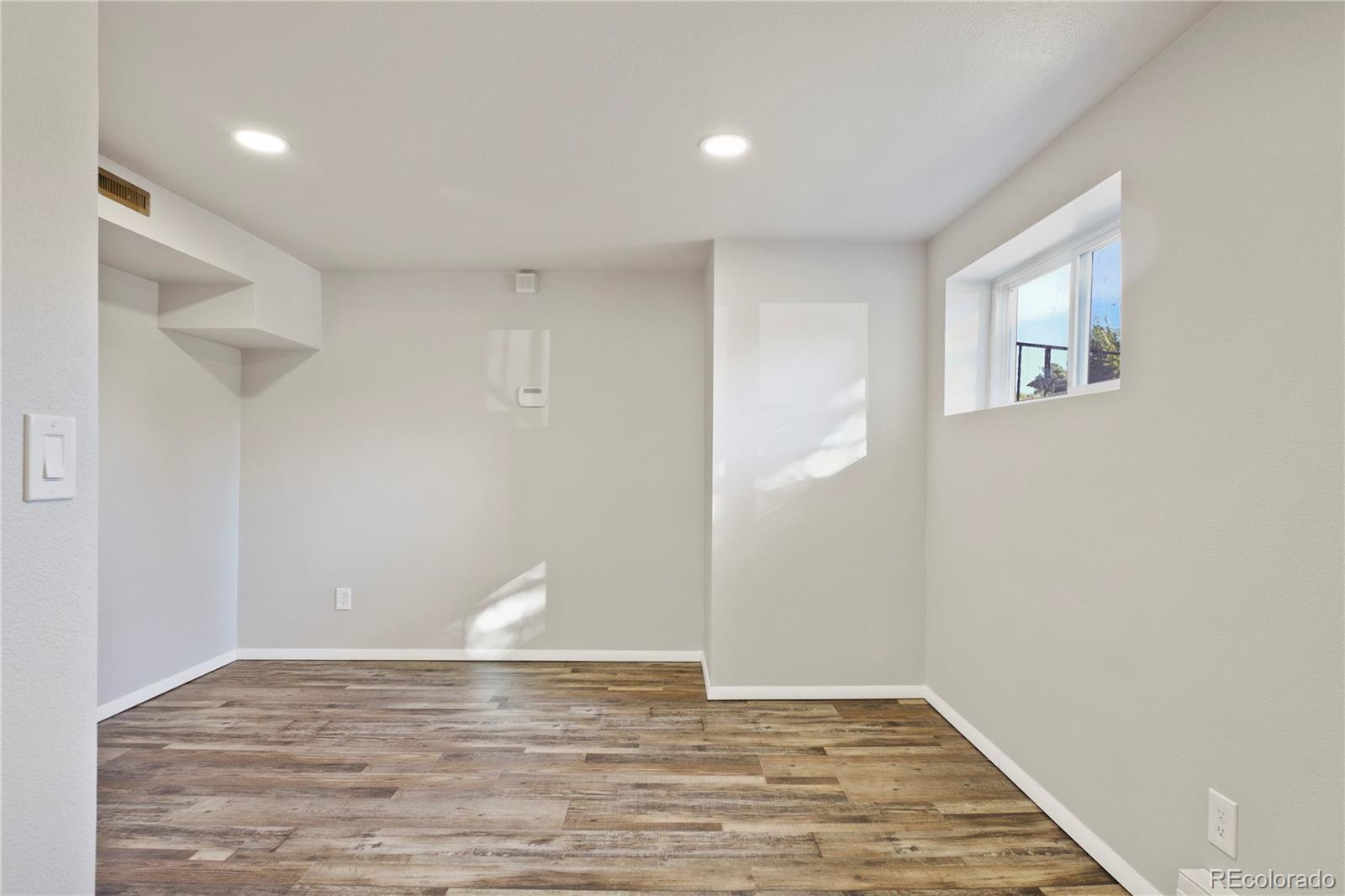 806 Paradise Lane Colorado Springs, CO 80904 - Photo 30 of 45 a view of an empty room with wooden floor and a window