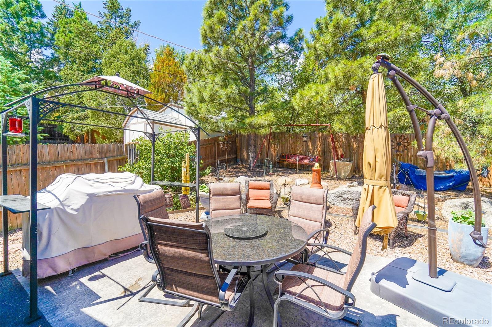 806 Paradise Lane Colorado Springs, CO 80904 - Photo 10 of 45 a view of a patio with table and chairs potted plants with wooden floor and fence